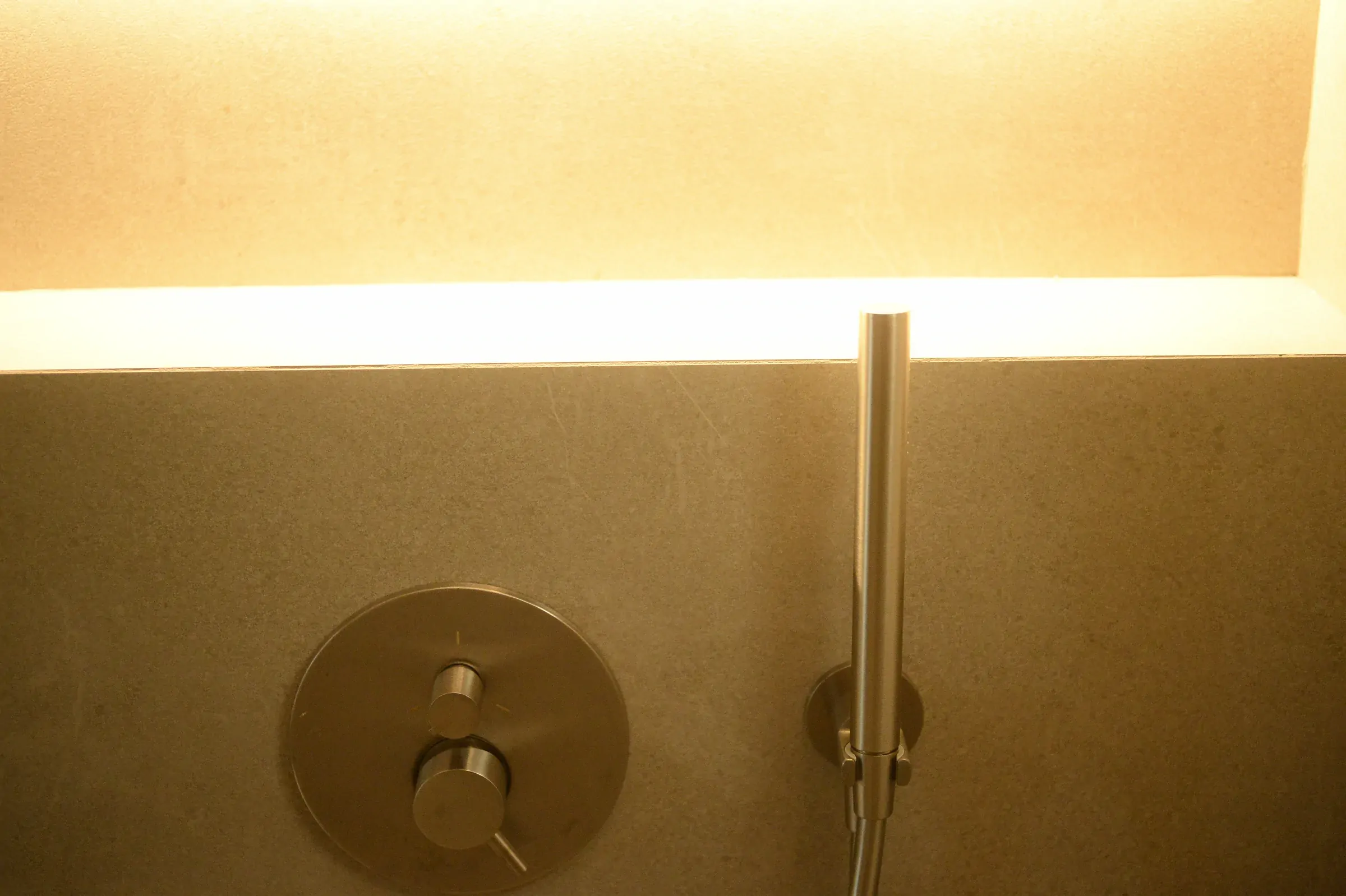 A warm horizontal light washes the shower-control zone.