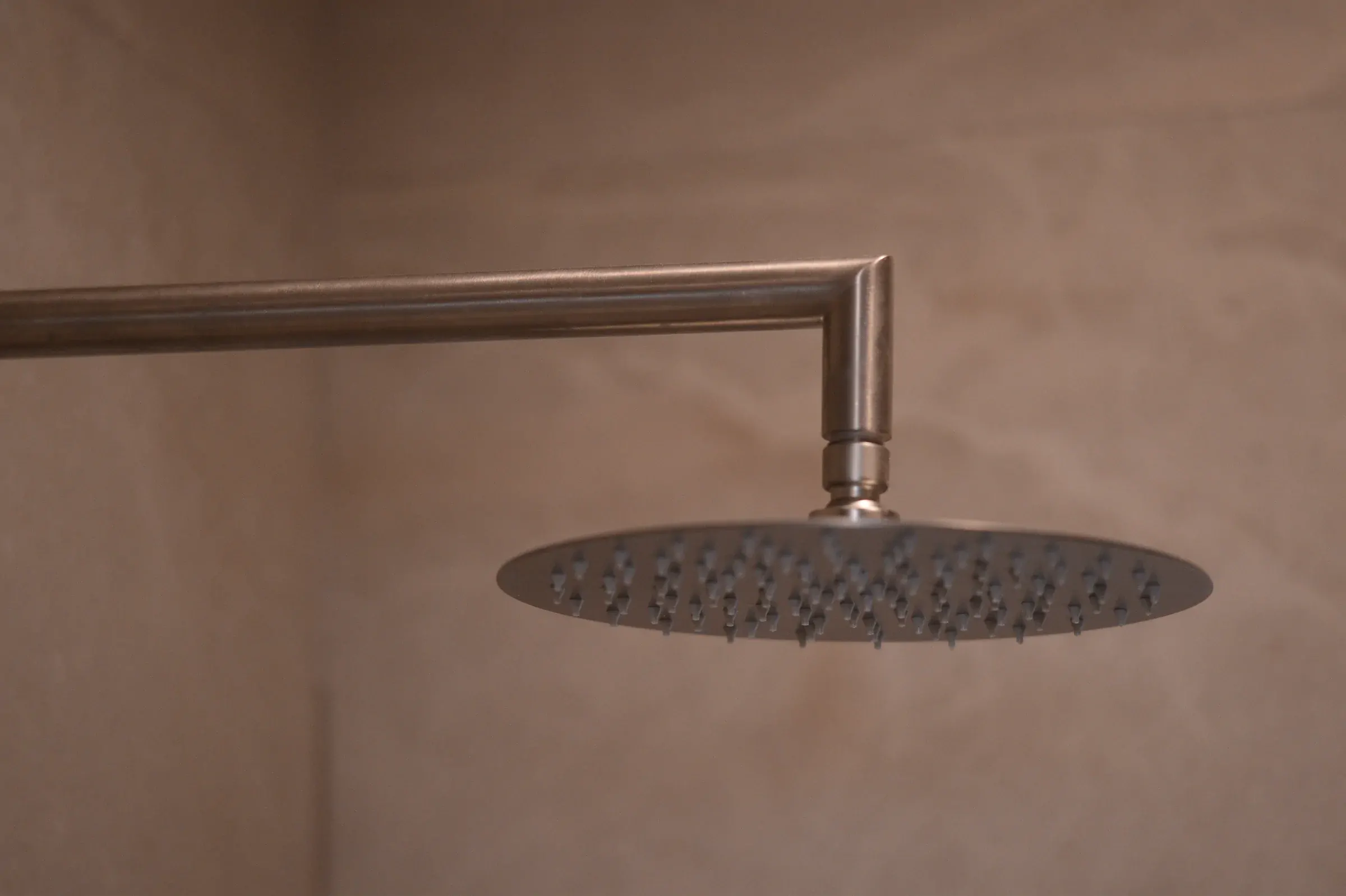 The circular rain shower is aligned with the large-format wall finish.