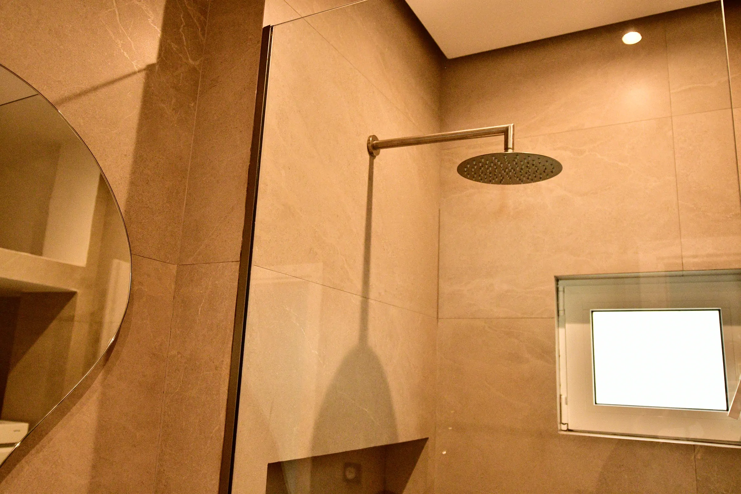 The transparent enclosure keeps the compact bathroom visually open.