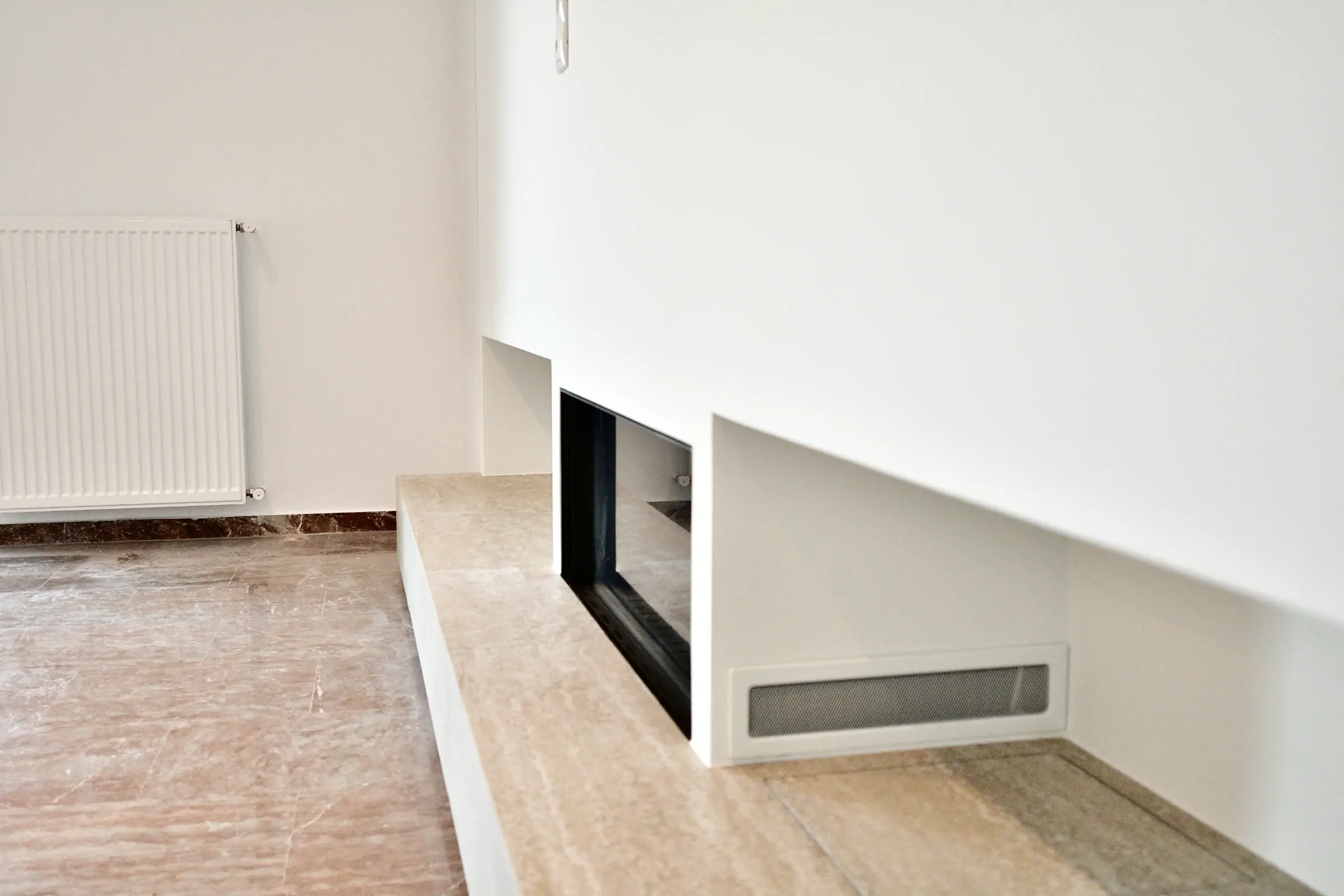 Fireplace, stone base and heating are coordinated as one functional system.