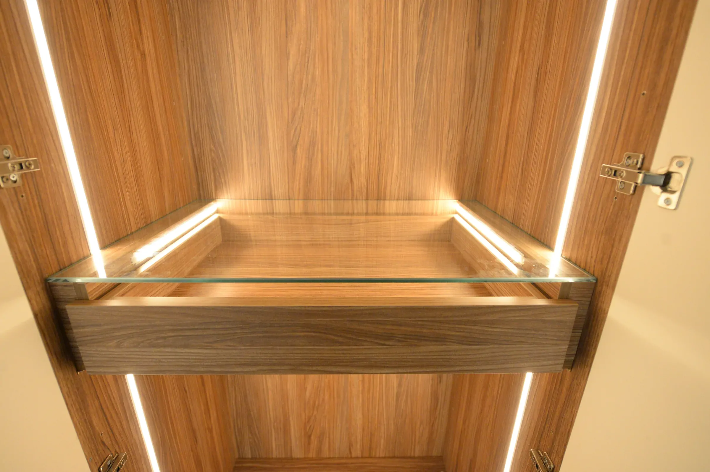 A fine line of light is integrated into the timber shelf.
