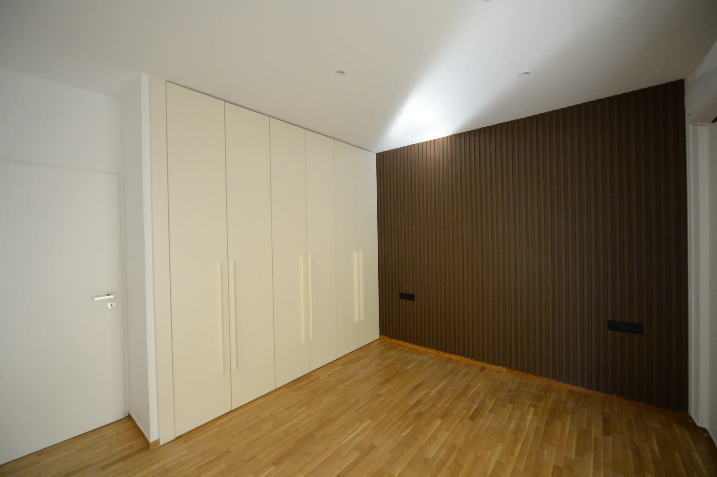 White fitted cabinetry meets the warm timber composition.