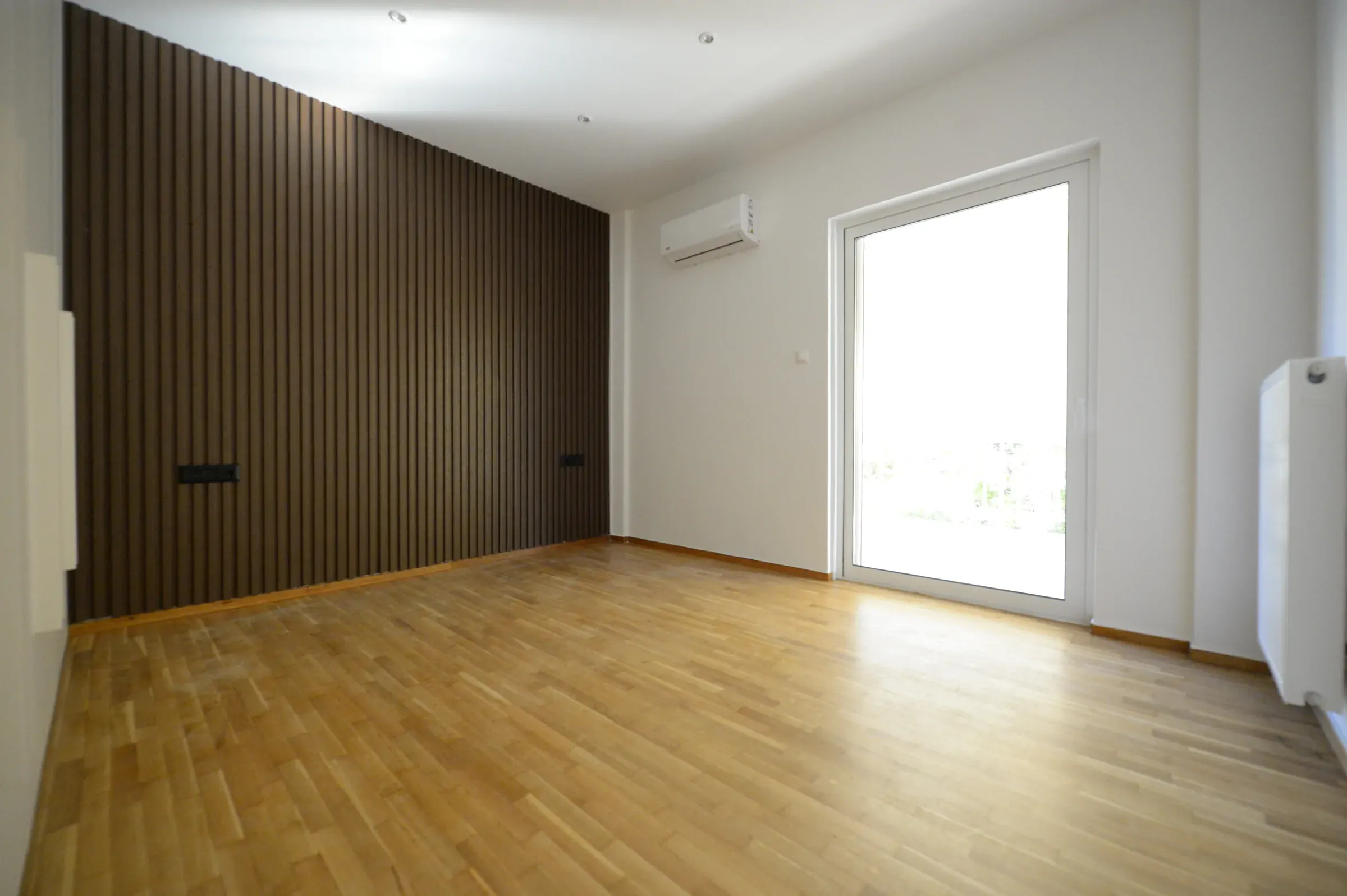The full-height ribbed timber wall gives the room warmth and depth.