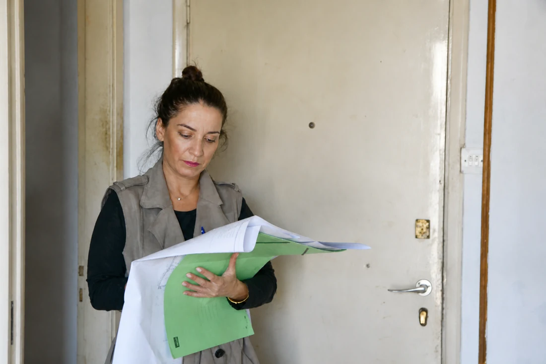 Η Αρχιτέκτων Μηχανικός Ιωάννα Σεφερλή με αρχιτεκτονικά σχέδια σε χώρο έργου
